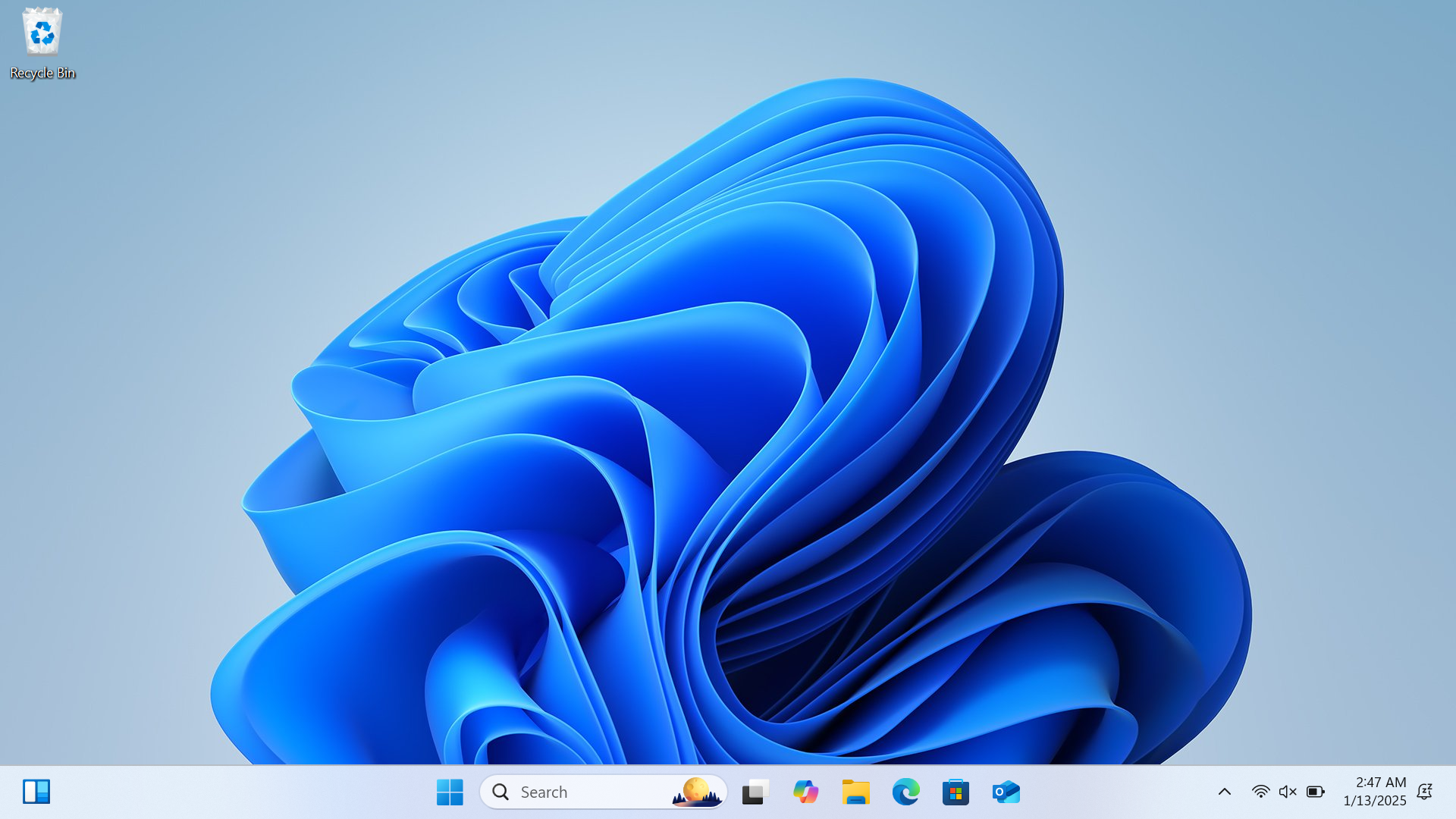 A screenshot of a Windows 11 desktop showing the default blue abstract wallpaper. The taskbar at the bottom includes icons for the Start menu, Search, Task View, Widgets, File Explorer, Microsoft Edge, and Microsoft Outlook. The system tray on the right shows the time as 2:47 AM on January 13, 2025, along with icons for network, volume, and battery status. The Recycle Bin icon is located in the top left corner of the desktop.